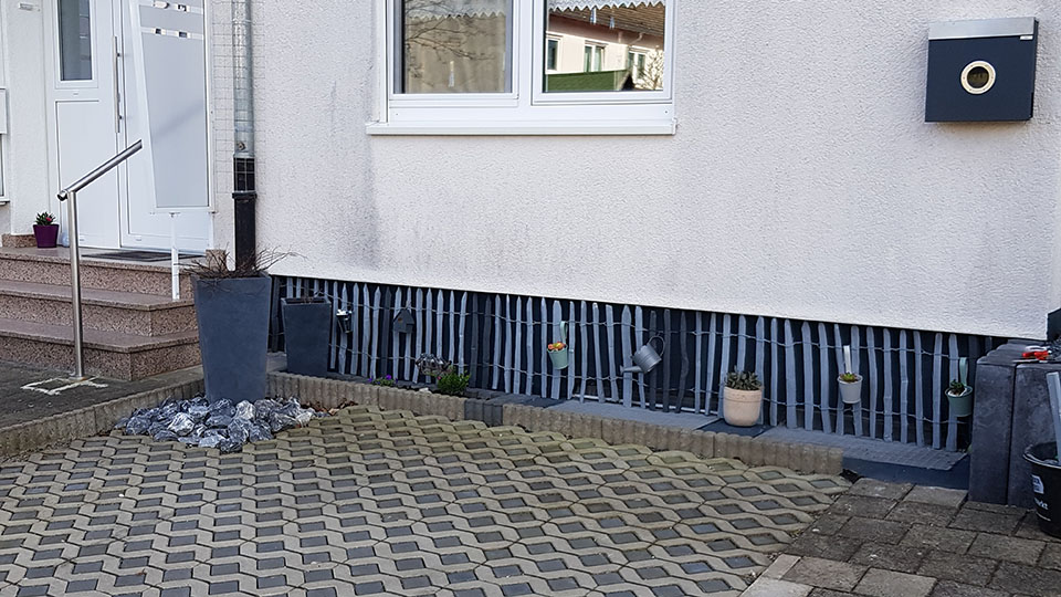 2911-1022 Staketenzaun blau gestrichen vor Haussockel