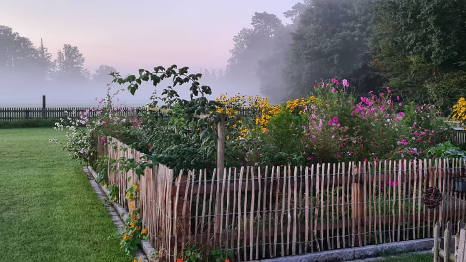 Staketenzaun Blumenbeeteinfassung im Nebel Staketenzaun Blumenbeeteinfassung im Nebel